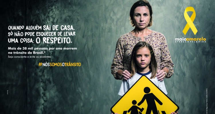 Campanha Maio Amarelo de segurança no transito. Na foto, mãe com uma criança
