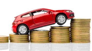Foto de capa de um carro em miniatura em cima de moedas