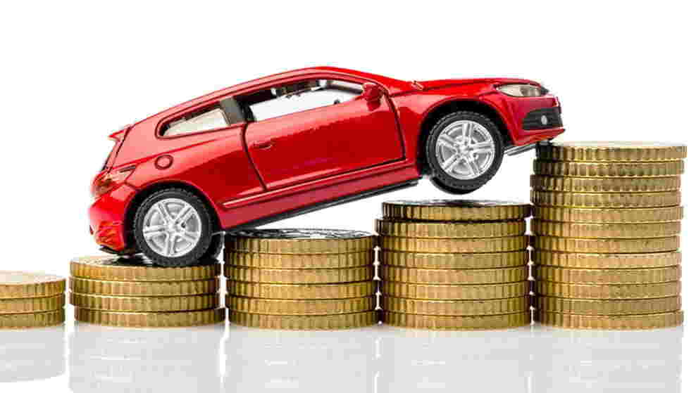 Foto de capa de um carro em miniatura em cima de moedas